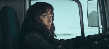 Movie still from “Heart of Stone” (2023), directed by Tom Harper – A woman sitting in the driver's seat of a car; Close Up shot, Low angle