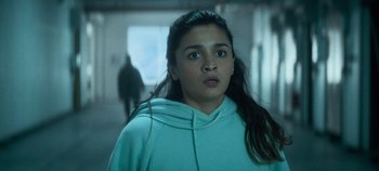 Movie still from “Heart of Stone” (2023), directed by Tom Harper – A young woman in a blue hoodie stares into the distance; Close Up shot, Low angle