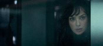 Movie still from “Heart of Stone” (2023), directed by Tom Harper – A person with long black hair; Close Up shot, Over the shoulder angle