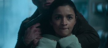 Movie still from “Heart of Stone” (2023), directed by Tom Harper – A young girl getting her hair brushed by a man; Close Up shot, Over the shoulder angle