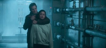 Movie still from “Heart of Stone” (2023), directed by Tom Harper – A man and a woman standing next to each other in front of pipes; Medium shot, Over the shoulder angle