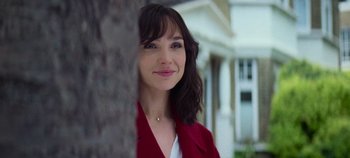 Movie still from “Heart of Stone” (2023), directed by Tom Harper – A woman in a red jacket standing next to a tree; Close Up shot, Over the shoulder angle
