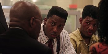 Movie still from “Heist 88” (2023), directed by Menhaj Huda – A man in a striped shirt and a red tie; Close Up shot, Over the shoulder angle