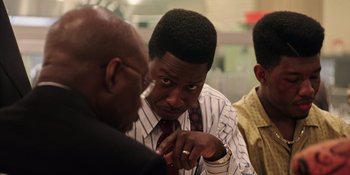 Movie still from “Heist 88” (2023), directed by Menhaj Huda – A group of people that are looking at each other; Close Up shot, Over the shoulder angle