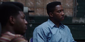 Movie still from “Heist 88” (2023), directed by Menhaj Huda – Two men are sitting in a room and one of them is wearing a striped shirt; Close Up shot, Over the shoulder angle