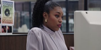 Movie still from “Heist 88” (2023), directed by Menhaj Huda – A woman in a white shirt is standing in front of a computer; Close Up shot, Over the shoulder angle