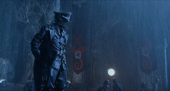 Movie still from “Hellboy” (2004), directed by Guillermo del Toro – A man in a nazi garb standing in the rain; Medium shot, Low angle