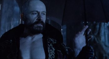 Movie still from “Hellboy” (2004), directed by Guillermo del Toro – A man with a bald head holding an umbrella; Close Up shot, Low angle