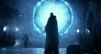 Movie still from “Hellboy” (2004), directed by Guillermo del Toro – A man standing in front of a wall in the rain; Wide shot, Over the shoulder angle
