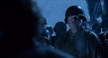 Movie still from “Hellboy” (2004), directed by Guillermo del Toro – A man wearing a helmet and a uniform in the dark; Close Up shot, Over the shoulder angle