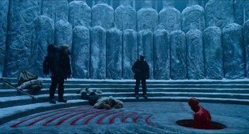 Movie still from “Hellboy” (2004), directed by Guillermo del Toro – Two people standing in front of a large stone wall; Extreme Wide shot, High angle