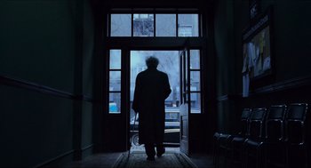 Movie still from “Hellboy” (2004), directed by Guillermo del Toro – An old man walking through a door way at night; Wide shot, Low angle