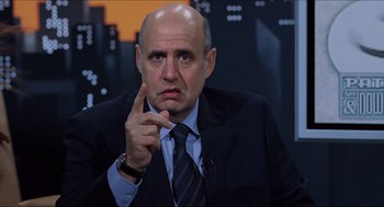 Movie still from “Hellboy” (2004), directed by Guillermo del Toro – A man in a suit and tie pointing to the side; Close Up shot, Over the shoulder angle