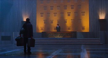 Movie still from “Hellboy” (2004), directed by Guillermo del Toro – A man standing in front of a building with a briefcase; Extreme Wide shot, Low angle