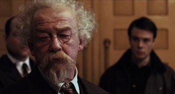 Movie still from “Hellboy” (2004), directed by Guillermo del Toro – An old man with a beard and a mustache; Close Up shot, Over the shoulder angle