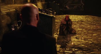 Movie still from “Hellboy” (2004), directed by Guillermo del Toro – A man sitting on the ground next to another man; Wide shot, Over the shoulder angle