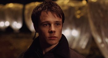 Movie still from “Hellboy” (2004), directed by Guillermo del Toro – A young man wearing a brown jacket and a pair of ear buds; Close Up shot, Low angle