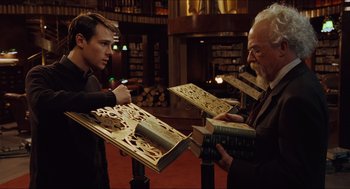 Movie still from “Hellboy” (2004), directed by Guillermo del Toro – Two men are looking at books in a library; Medium shot, Over the shoulder angle