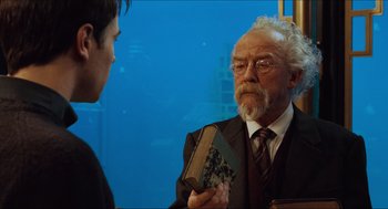 Movie still from “Hellboy” (2004), directed by Guillermo del Toro – An older man holding a book in front of a young man; Close Up shot, Over the shoulder angle