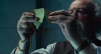 Movie still from “Hellboy” (2004), directed by Guillermo del Toro – An older man holding a piece of paper in his hands; Close Up shot, Low angle