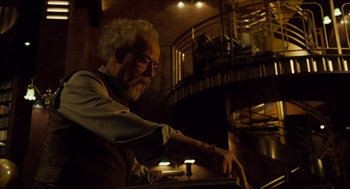 Movie still from “Hellboy” (2004), directed by Guillermo del Toro – An older man in glasses is looking at a light; Medium shot, Low angle