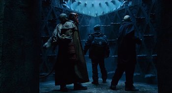 Movie still from “Hellboy” (2004), directed by Guillermo del Toro – A group of people standing around in a room; Wide shot, Low angle