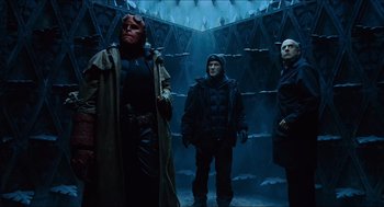 Movie still from “Hellboy” (2004), directed by Guillermo del Toro – A group of men standing next to each other in a room; Wide shot, Low angle