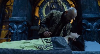 Movie still from “Hellboy” (2004), directed by Guillermo del Toro – A man in a black and gold jacket is standing next to a woman; Medium shot, Overhead angle