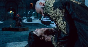 Movie still from “Hellboy” (2004), directed by Guillermo del Toro – A man and a woman in a black and gold dress; Medium shot, Over the shoulder angle