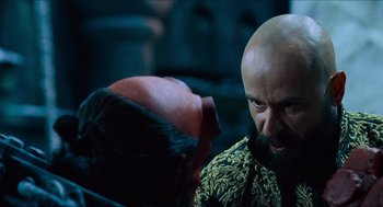 Movie still from “Hellboy” (2004), directed by Guillermo del Toro – A man with a bald head talking to another man; Close Up shot, Over the shoulder angle