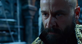 Movie still from “Hellboy” (2004), directed by Guillermo del Toro – A man with a long beard is looking into the distance; Close Up shot, Low angle
