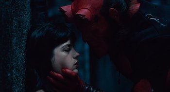 Movie still from “Hellboy” (2004), directed by Guillermo del Toro – A man and a woman in a dark room with red gloves on; Close Up shot, Overhead angle