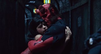 Movie still from “Hellboy” (2004), directed by Guillermo del Toro – A man and a woman hugging in a dark room; Medium shot, High angle