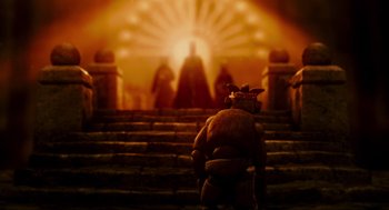 Movie still from “Hellboy II: The Golden Army” (2008), directed by Guillermo del Toro – A person standing on some steps in front of some statues; Wide shot, Low angle