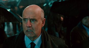 Movie still from “Hellboy II: The Golden Army” (2008), directed by Guillermo del Toro – An older man with a bald head wearing a tie; Close Up shot, Over the shoulder angle