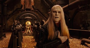 Movie still from “Hellboy II: The Golden Army” (2008), directed by Guillermo del Toro – A man with long blonde hair wearing a black jacket; Medium shot, Over the shoulder angle