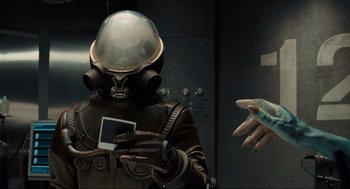 Movie still from “Hellboy II: The Golden Army” (2008), directed by Guillermo del Toro – A man in a space suit holding a cell phone; Medium shot, Over the shoulder angle