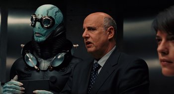 Movie still from “Hellboy II: The Golden Army” (2008), directed by Guillermo del Toro – A man in a suit and tie next to a robot; Medium shot, Over the shoulder angle