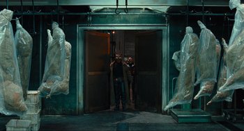 Movie still from “Hellboy II: The Golden Army” (2008), directed by Guillermo del Toro – Two men standing in front of an entrance to a building; Wide shot, Low angle