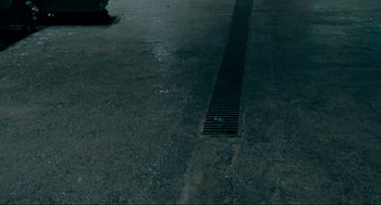 Movie still from “Hellboy II: The Golden Army” (2008), directed by Guillermo del Toro – A street drain on the side of the road; Extreme Wide shot, High angle