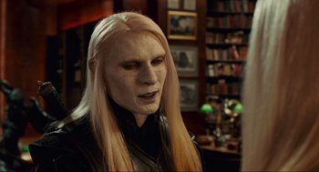 Movie still from “Hellboy II: The Golden Army” (2008), directed by Guillermo del Toro – A man with long blonde hair wearing a white mask; Close Up shot, Over the shoulder angle