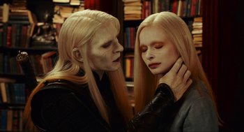 Movie still from “Hellboy II: The Golden Army” (2008), directed by Guillermo del Toro – Two people with long blonde hair and one has a white face and one has blond hair and one has blond hair; Close Up shot, Over the shoulder angle