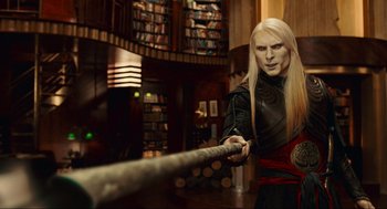 Movie still from “Hellboy II: The Golden Army” (2008), directed by Guillermo del Toro – A man with long blonde hair pulling on a rope; Medium shot, Over the shoulder angle