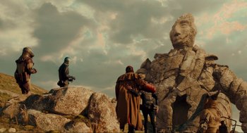 Movie still from “Hellboy II: The Golden Army” (2008), directed by Guillermo del Toro – A group of people standing on top of a rock formation; Extreme Wide shot, Low angle