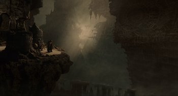 Movie still from “Hellboy II: The Golden Army” (2008), directed by Guillermo del Toro – A man sitting on a rock in a cave; Extreme Wide shot, High angle