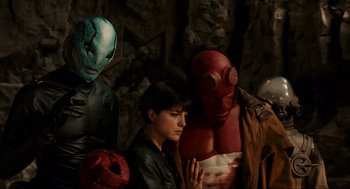 Movie still from “Hellboy II: The Golden Army” (2008), directed by Guillermo del Toro – A group of people standing next to each other in a cave; Medium shot, High angle
