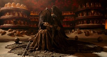 Movie still from “Hellboy II: The Golden Army” (2008), directed by Guillermo del Toro – An image of a woman sitting on a chair in a dark room; Wide shot, High angle