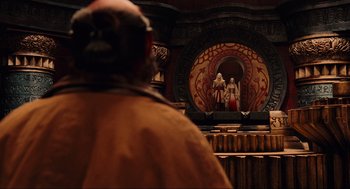 Movie still from “Hellboy II: The Golden Army” (2008), directed by Guillermo del Toro – A man standing in front of a painting of two women; Wide shot, Over the shoulder angle