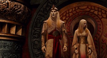 Movie still from “Hellboy II: The Golden Army” (2008), directed by Guillermo del Toro – A man in a costume stands next to a woman in a costume; Medium shot, Low angle