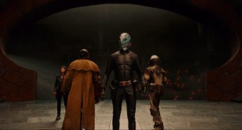 Movie still from “Hellboy II: The Golden Army” (2008), directed by Guillermo del Toro – A group of people standing in front of a wall; Wide shot, Low angle